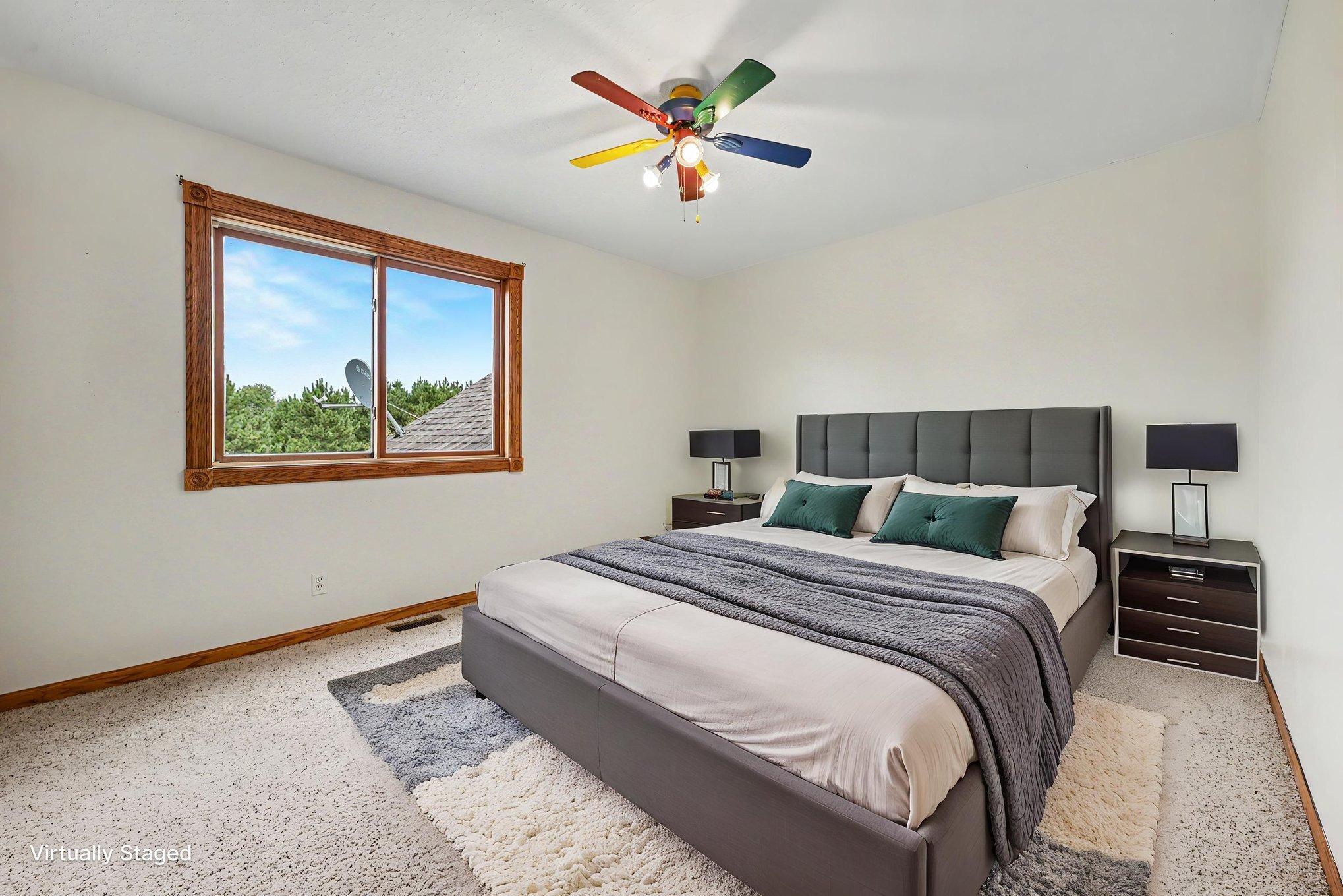 Main-level bedroom #2, virtually staged to showcase potential furniture placement and use of the space.