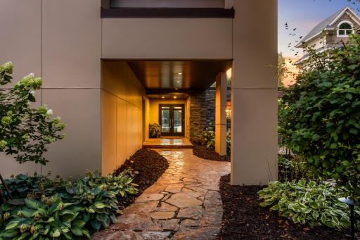 Covered Front Entry w/Water Feature. Lush Plantings and Pavered Patio's and Walkways.
