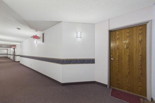 Brightly lit halls lead to this second floor corner unit.