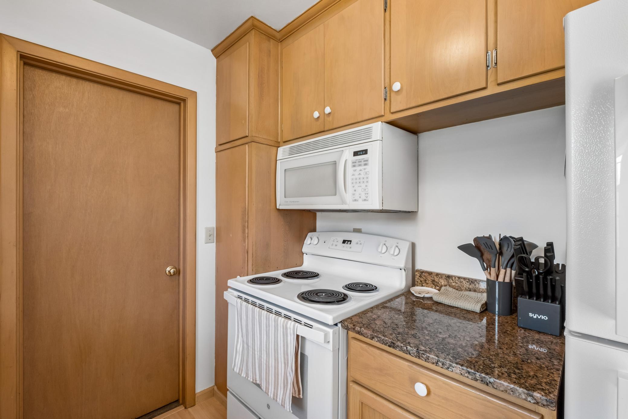 Kitchen with cabinets to the ceiling and pantry to the left of the stove.