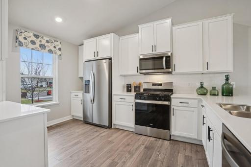 The kitchen is a chef's dream with stainless appliances, quartz counters and classic subway tile backsplash! colors and finishes may vary!