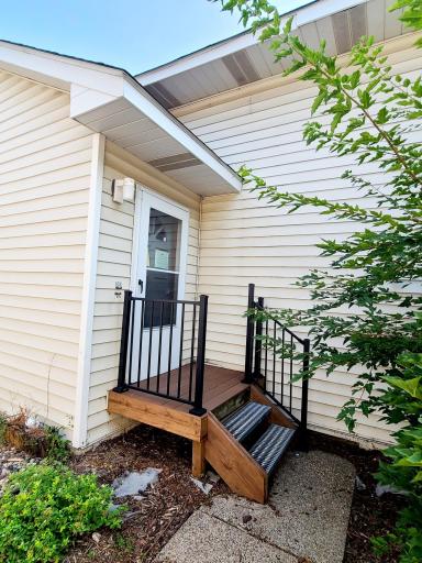 Private entryway tucked behind lush greenery, with space in between the buildings for bike storage.