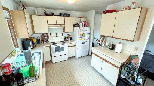 Kitchen view with white appliances, ample cabinetry