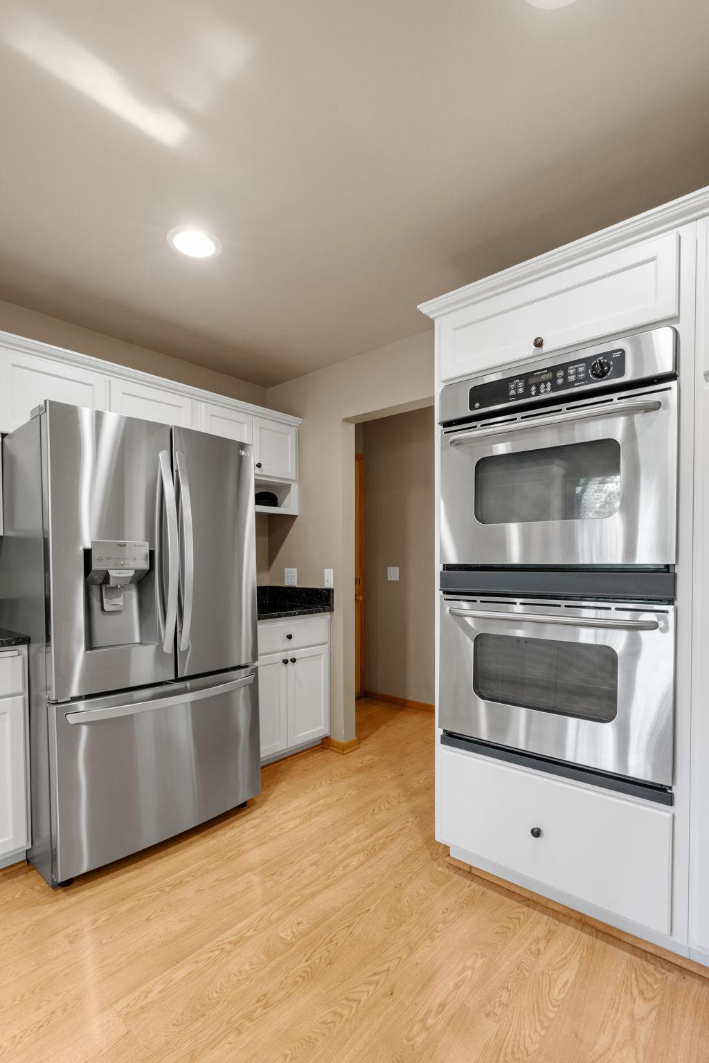 Nicely updated kitchen with custom cabinets, double wall ovens, stainless steel appliances, granite countertops, an undermount sink, and plenty of space! A window overlooks the deck and backyard.