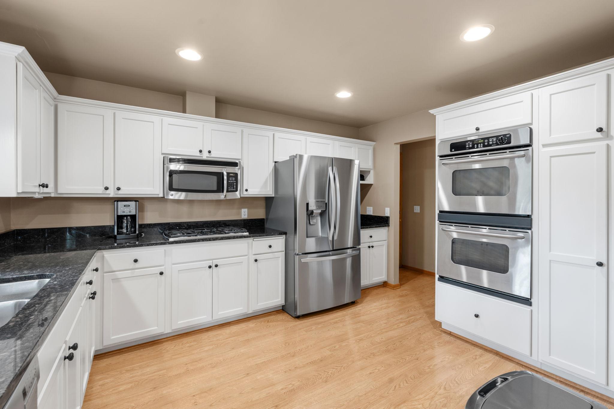 Nicely updated kitchen with custom cabinets, double wall ovens, stainless steel appliances, granite countertops, an undermount sink, and plenty of space! A window overlooks the deck and backyard.
