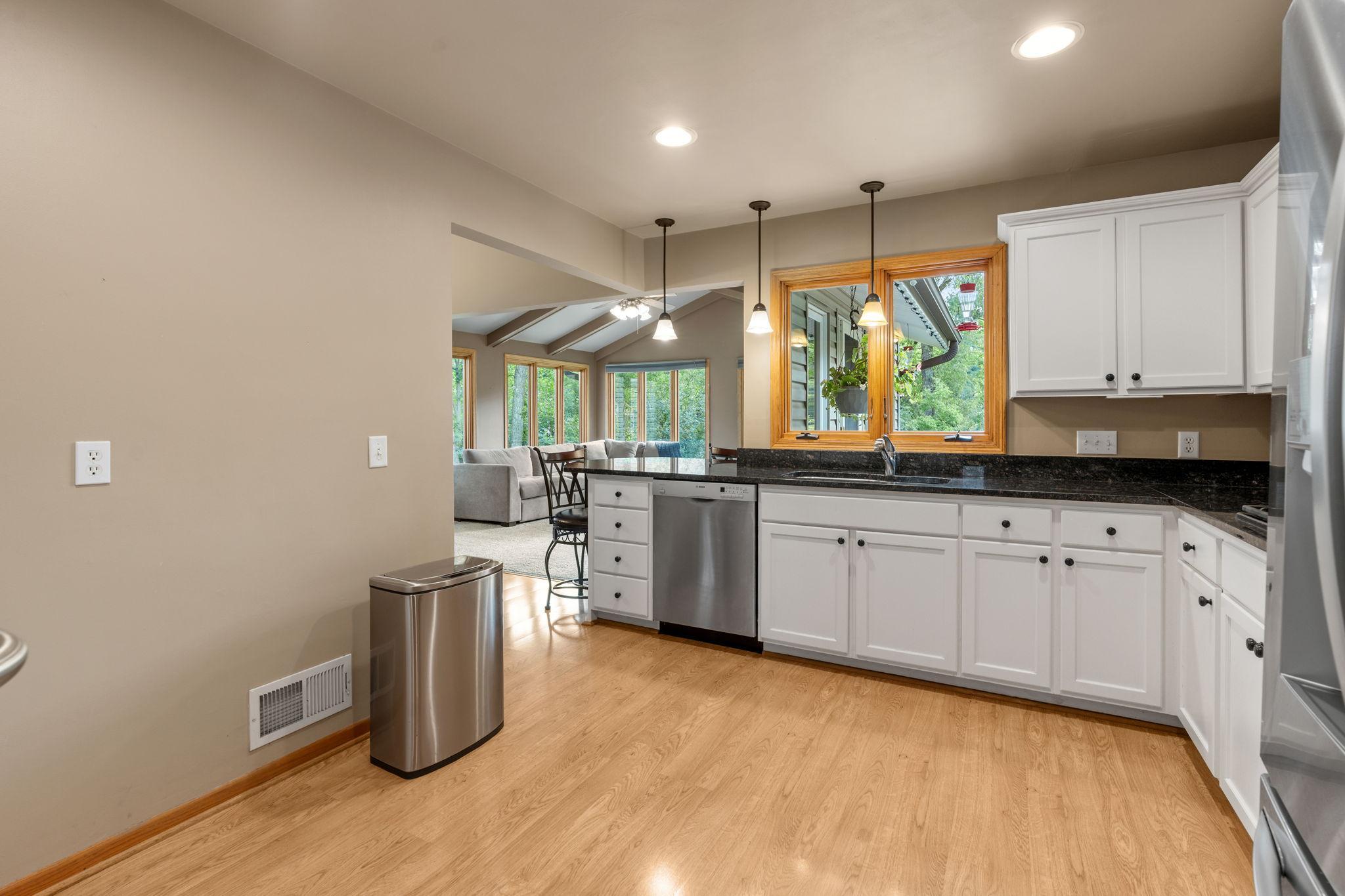 Nicely updated kitchen with custom cabinets, double wall ovens, stainless steel appliances, granite countertops, an undermount sink, and plenty of space! A window overlooks the deck and backyard.