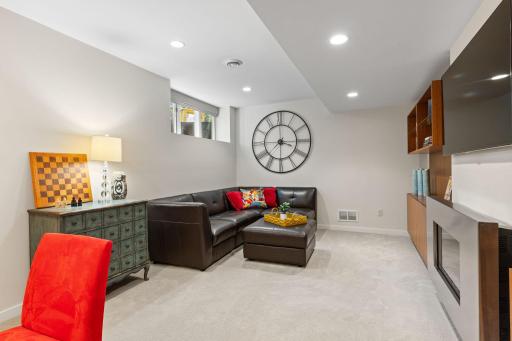 The large recreation room features built-ins surrounding a fireplace.