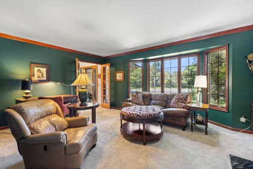 The main level immediately stands out with its unique details and inviting spaces. The living room feels warm and timeless with a full wall of custom built-ins, classic crown molding, and French doors that bring an added sense of charm and elegance.
