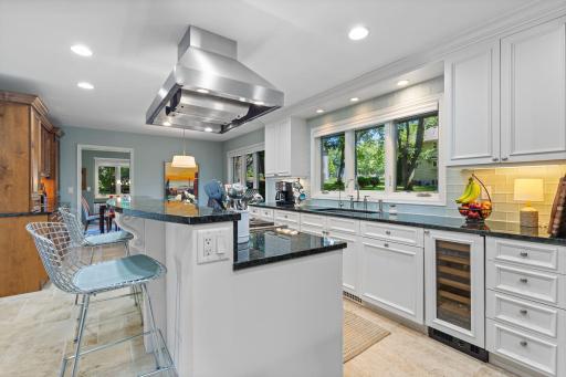 Under-cabinet lighting, tile backsplash, and an oversized two-tier island with seating.