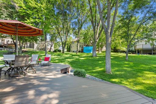 Outside, the backyard offers a peaceful extension of the home with a spacious Trex deck (2019), mature landscaping, and open views to surrounding greenspace without fences interrupting the scenery.