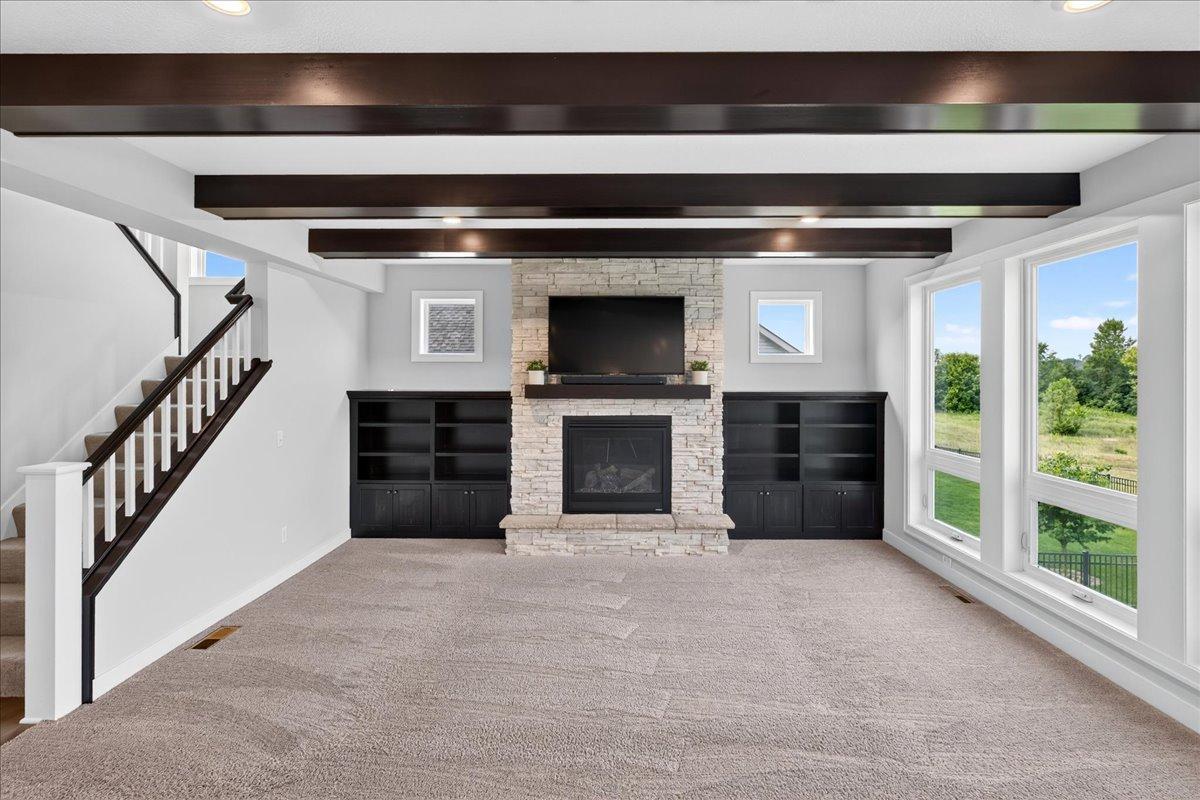 Beams and stone to the ceiling gas fireplace w/custom built-ins make this a true gathering place.