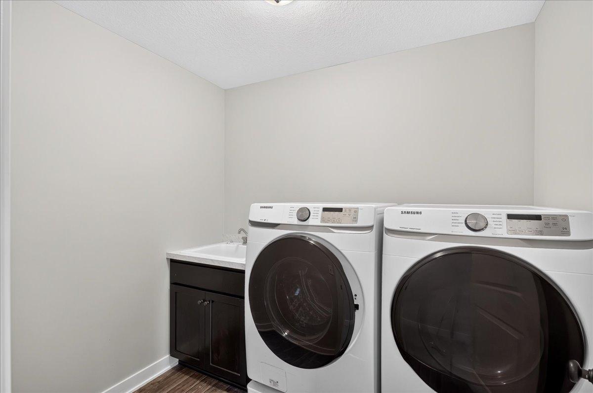 Front load washer/dryer on pedestals are enhanced by a laundry sink