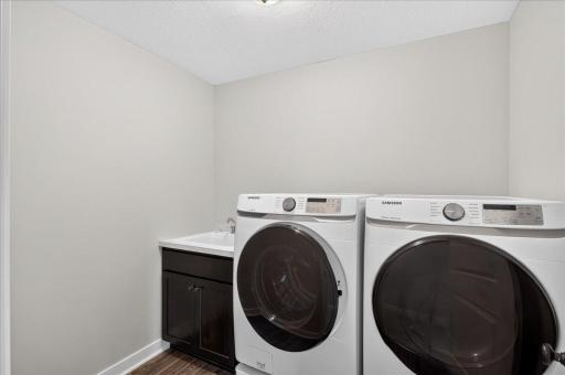 Front load washer/dryer on pedestals are enhanced by a laundry sink