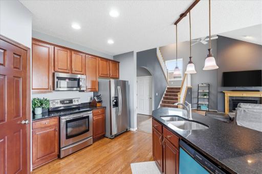 Kitchen featuring granite countertops, custom cabinetry, and stainless steel appliances.