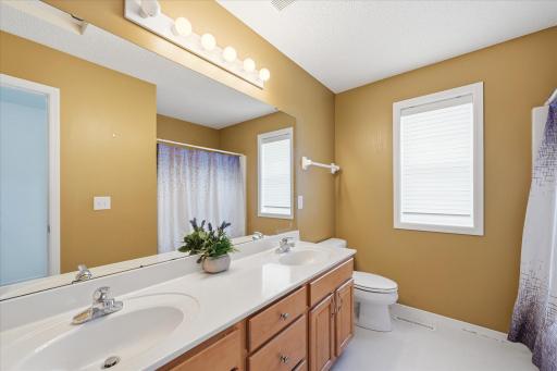 Upper level full bathroom with dual-sink vanity provides added convenience and functionality.