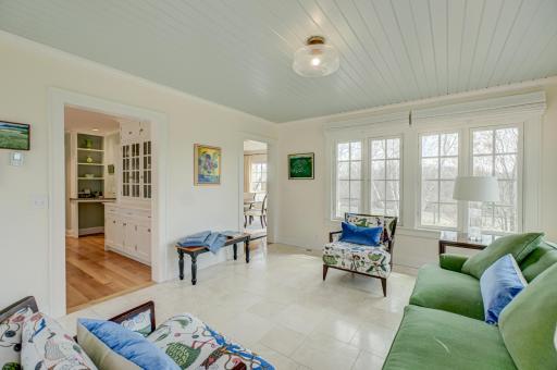 Step into this inviting sunroom just off the kitchen, where walls of south-facing windows create the perfect space to unwind and take in the year-round views