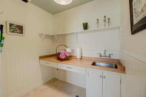 Entertaining is effortless with this convenient Butlerâs Pantry just off the kitchen, featuring a serving sink and direct access to the garage