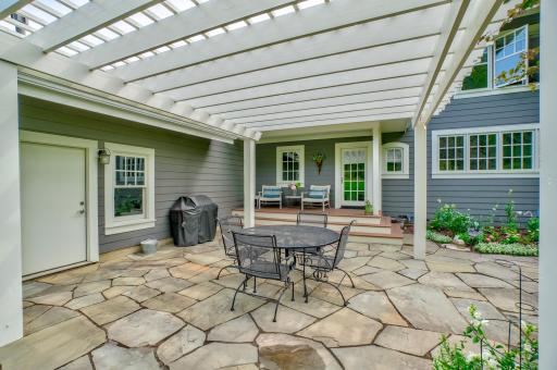 Enjoy outdoor living at its best on this patio, complete with lush grass and stunning landscaping all around