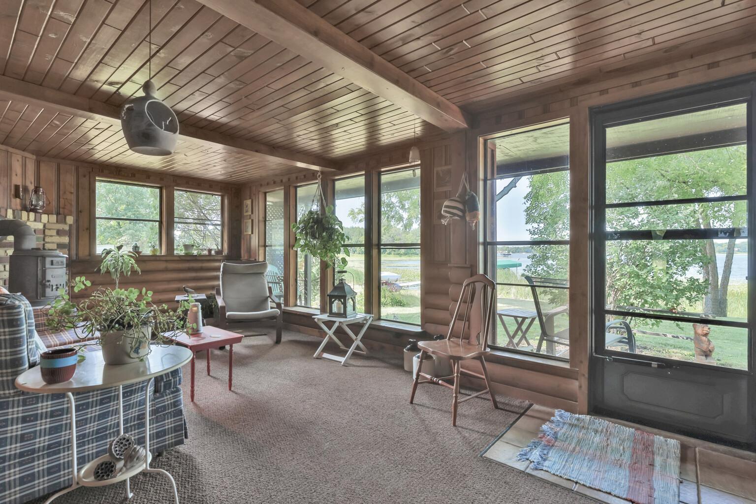 Lake front seasonal porch with wood ceiling and full windows to the water.