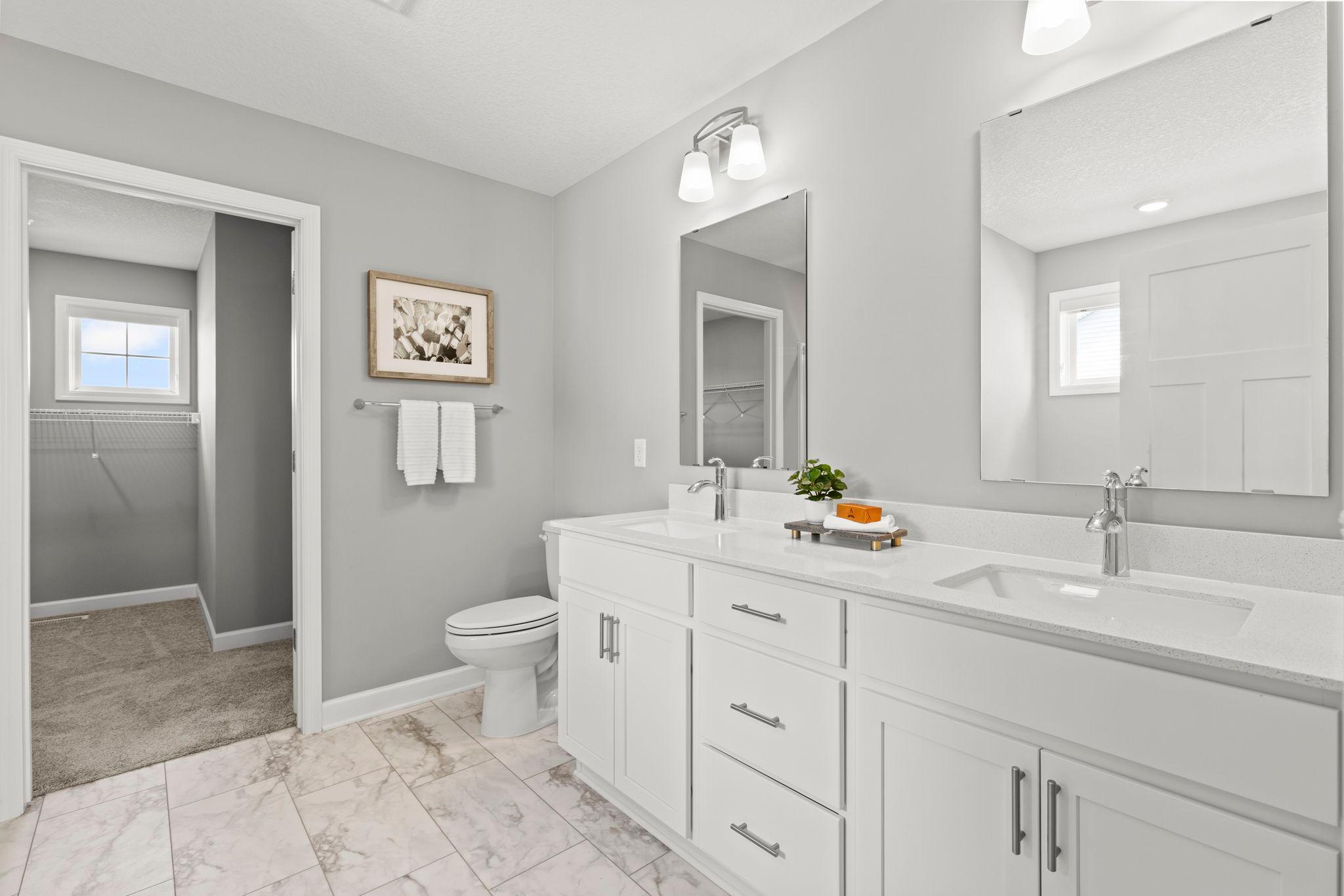 The private ensuite with dual vanities, a soaking tub, separate walk-in shower, and an impressive 10' x 9' walk-in closet.