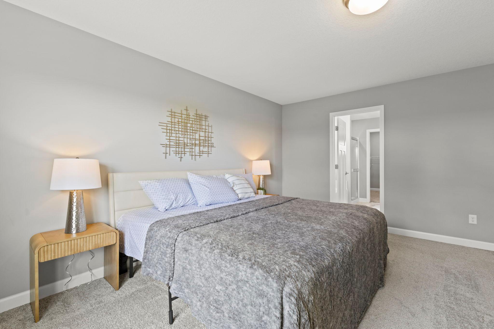 Additional view of the primary bedroom highlighting the entry to the private ensuite bathroom.