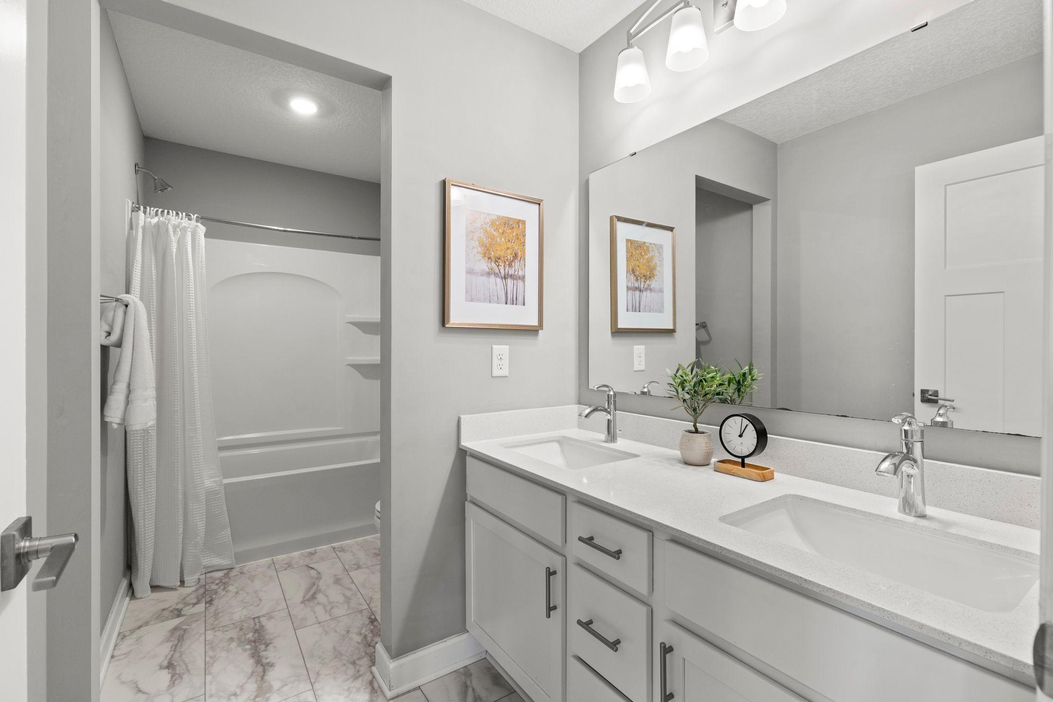 Conveniently located near all bedrooms is a shared full bathroom with dual vanities and a tub/shower combination.