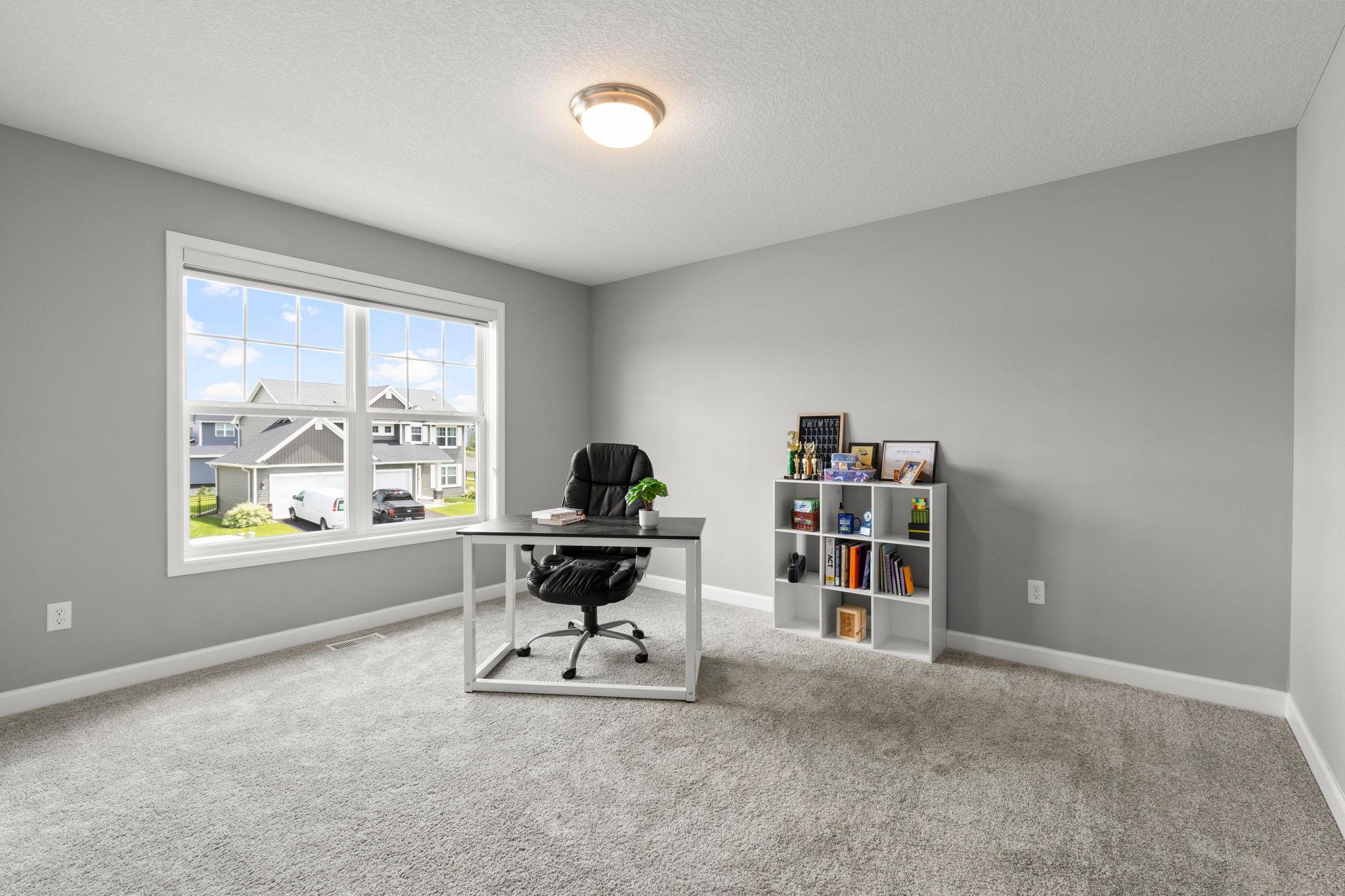 Fourth bedroom with front-facing exposure, large window, and walk-in closet.