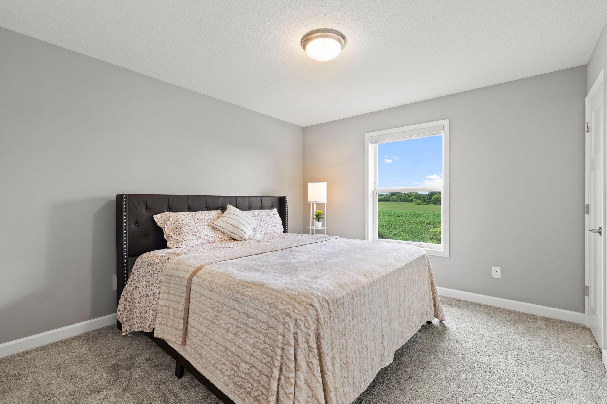 Bedroom two with carpeting and a walk-in closet.