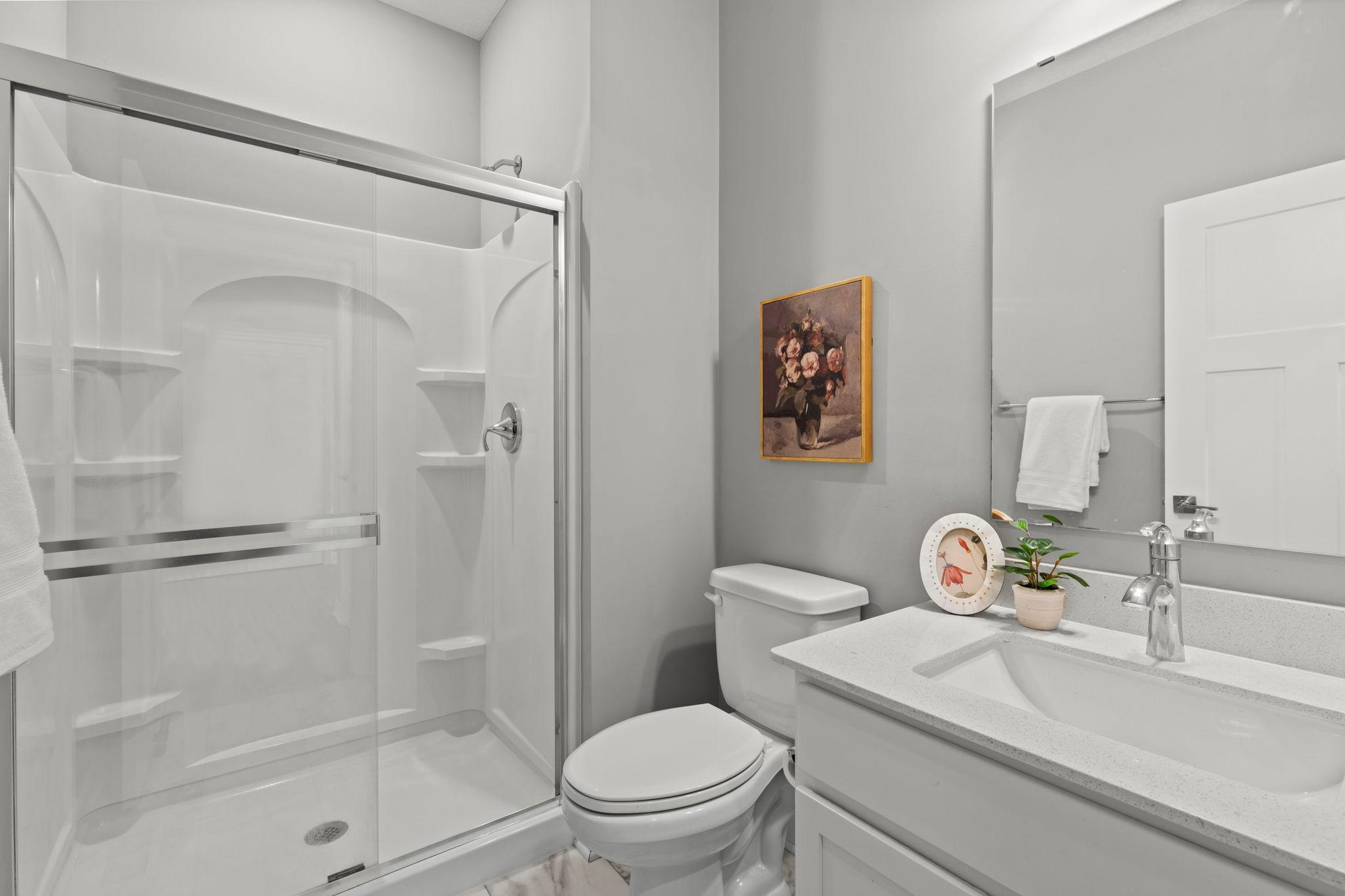 The bedroom is conveniently located next to a three-quarter bathroom featuring a walk-in shower.