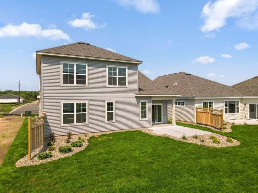 Rear of the Magnolia villa home - includes a patio, a portion of which is covered, plus a cedar privacy fence. Landscaping is also included.