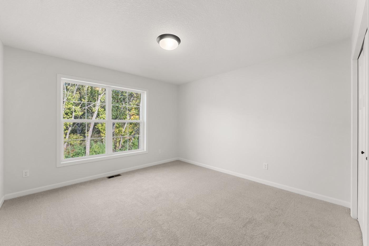 First upper level bedroom - overlooks the backyard with view of the mature trees