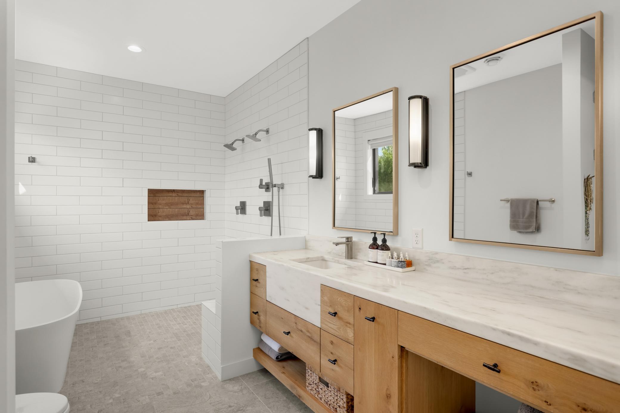 Wet room with 2 shower heads, custom white oak cabinetry, danbury marble counter and sink apron. Heated limestone floors