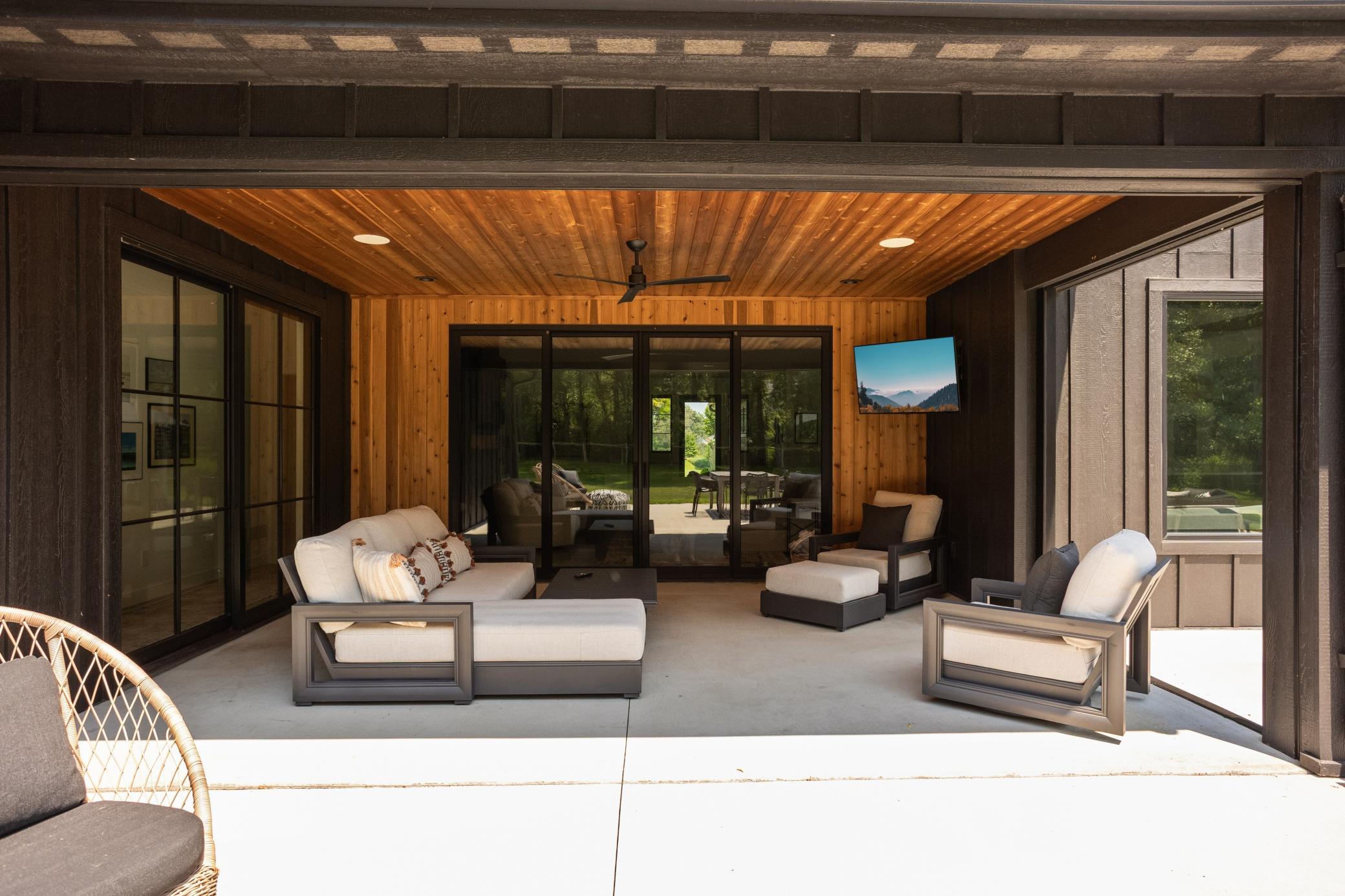 Covered patio with phantom screens and 8 foot Marvin bi-fold doors creates seamless indoor/outdoor living