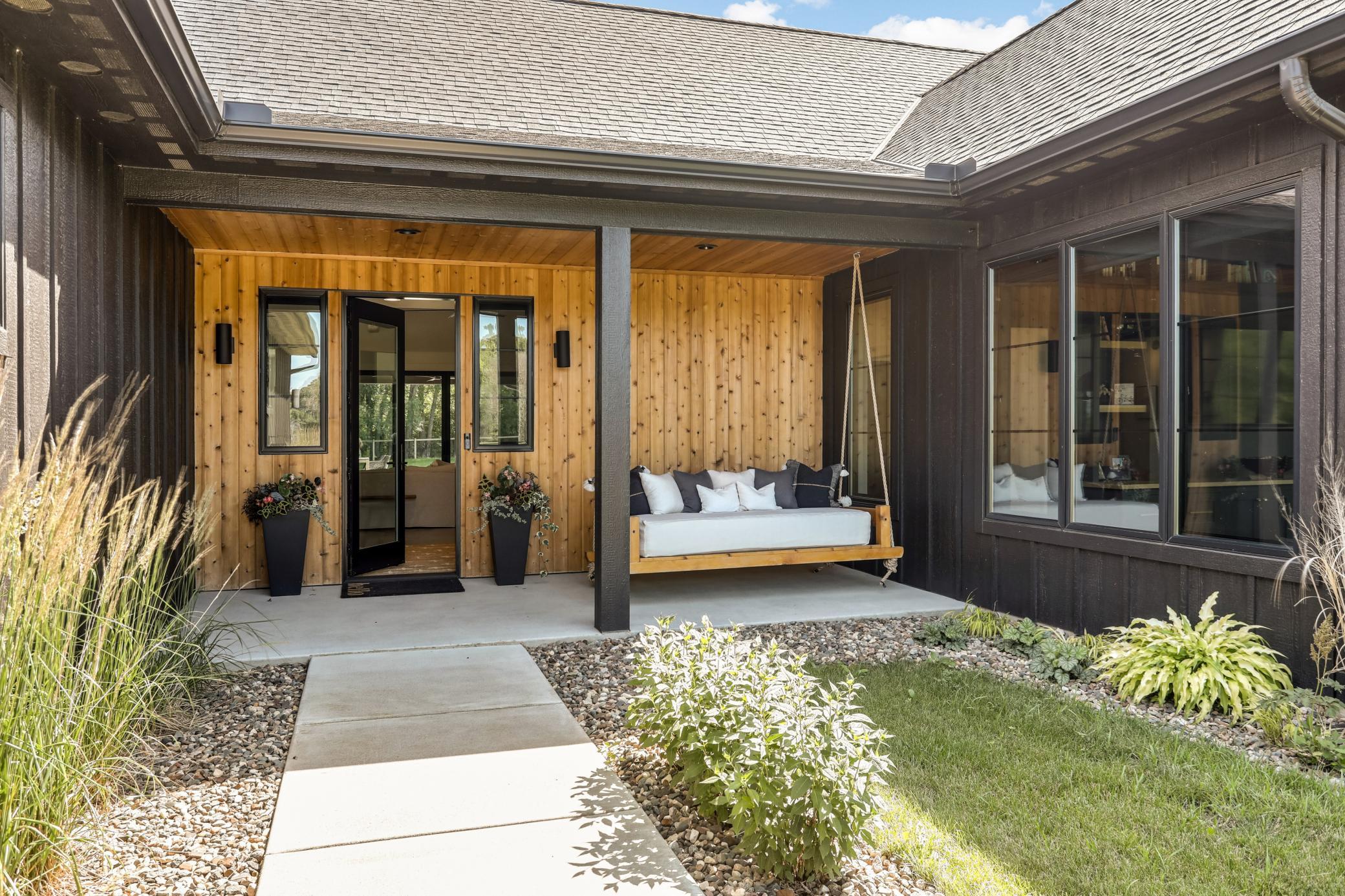 Tall grasses and charming day bed swing welcome your guests