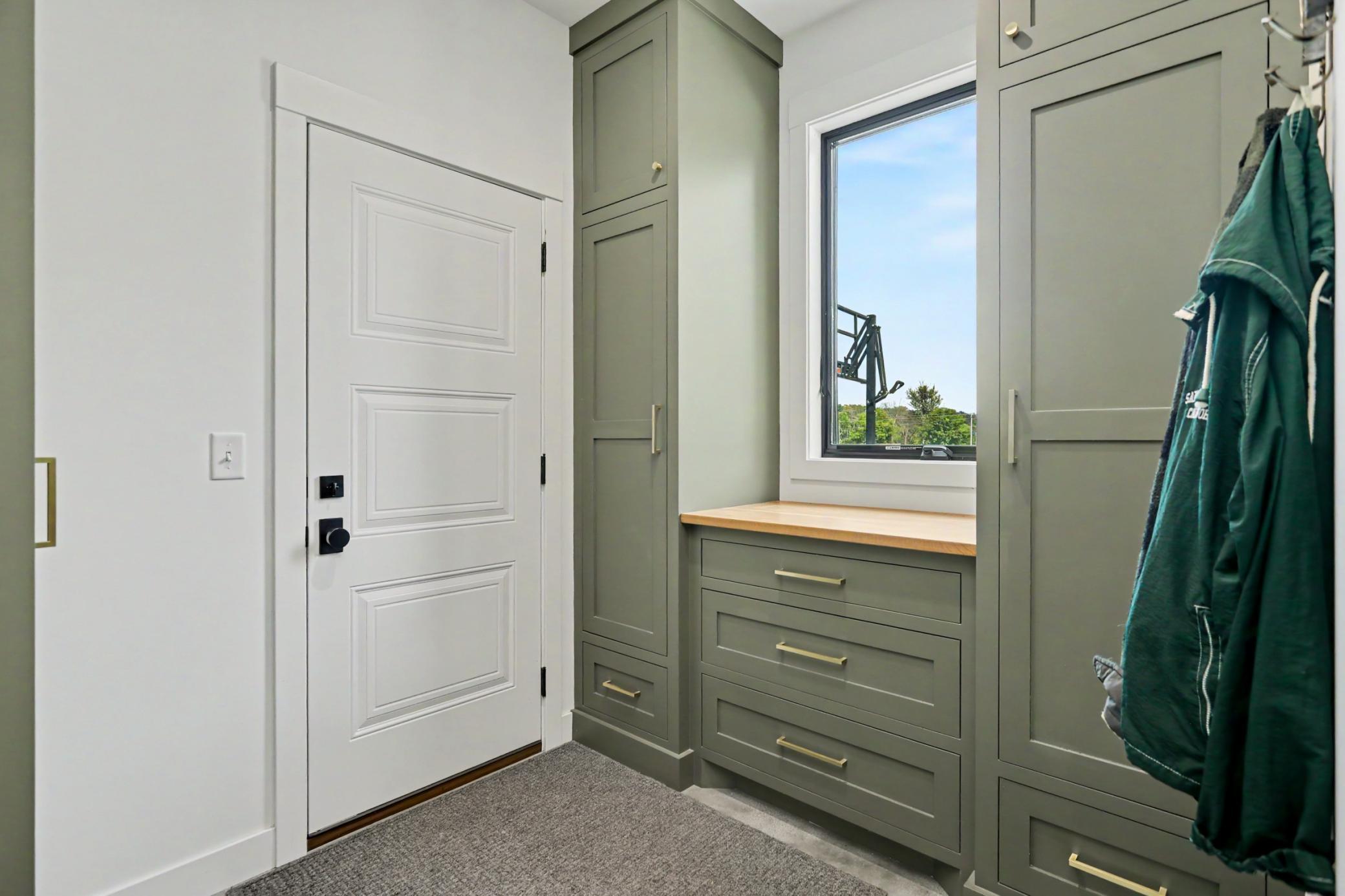 Custom cabinetry painted on site follows through into the charming mudroom