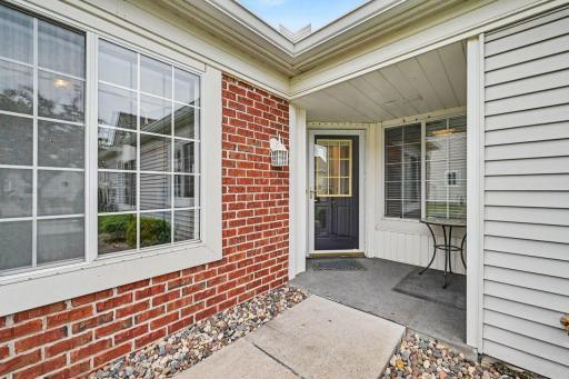 Welcoming front entry with vinyl with brick accents.