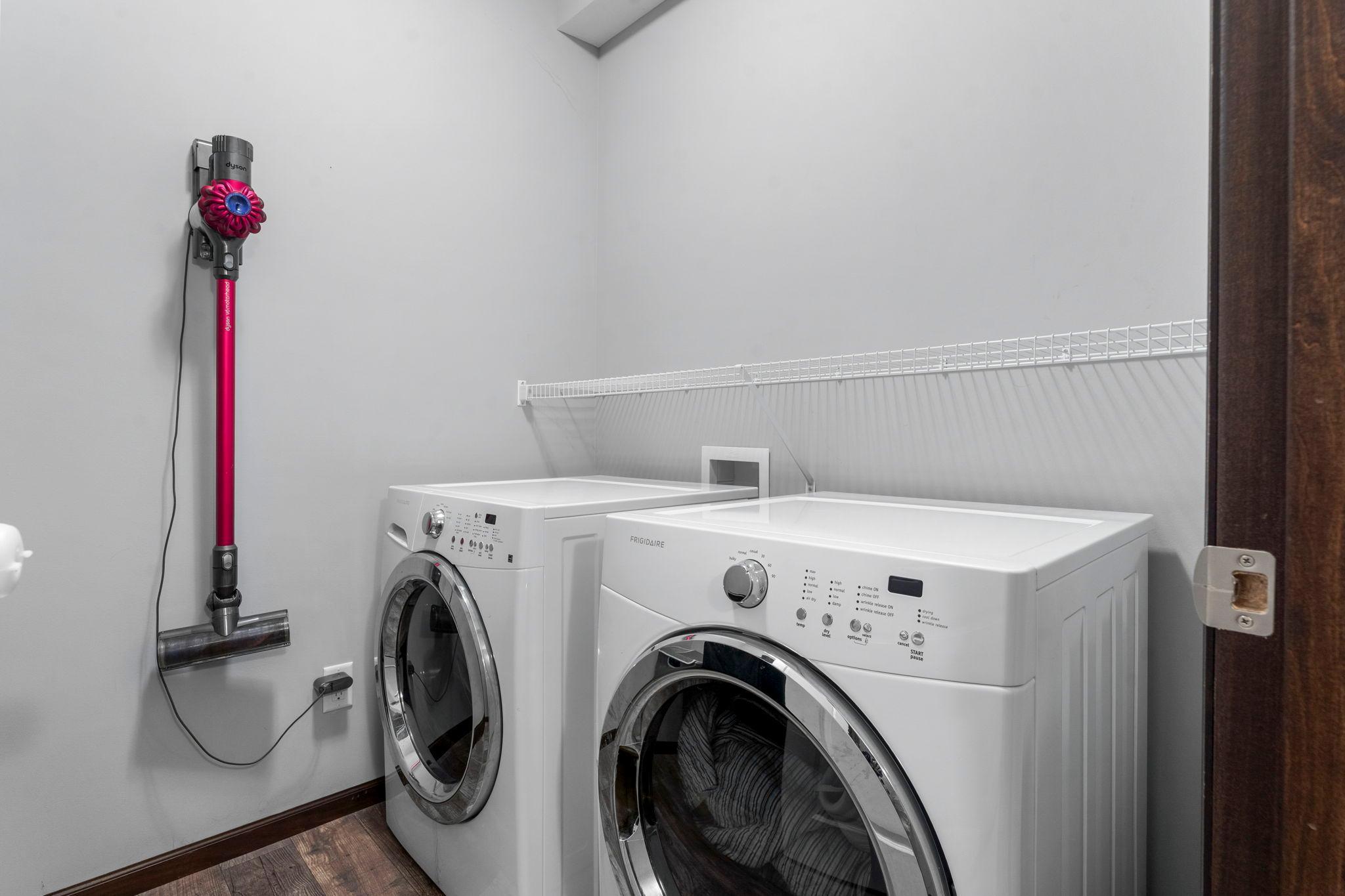 Nearby is a second laundry area with front-loading washer and dryer.