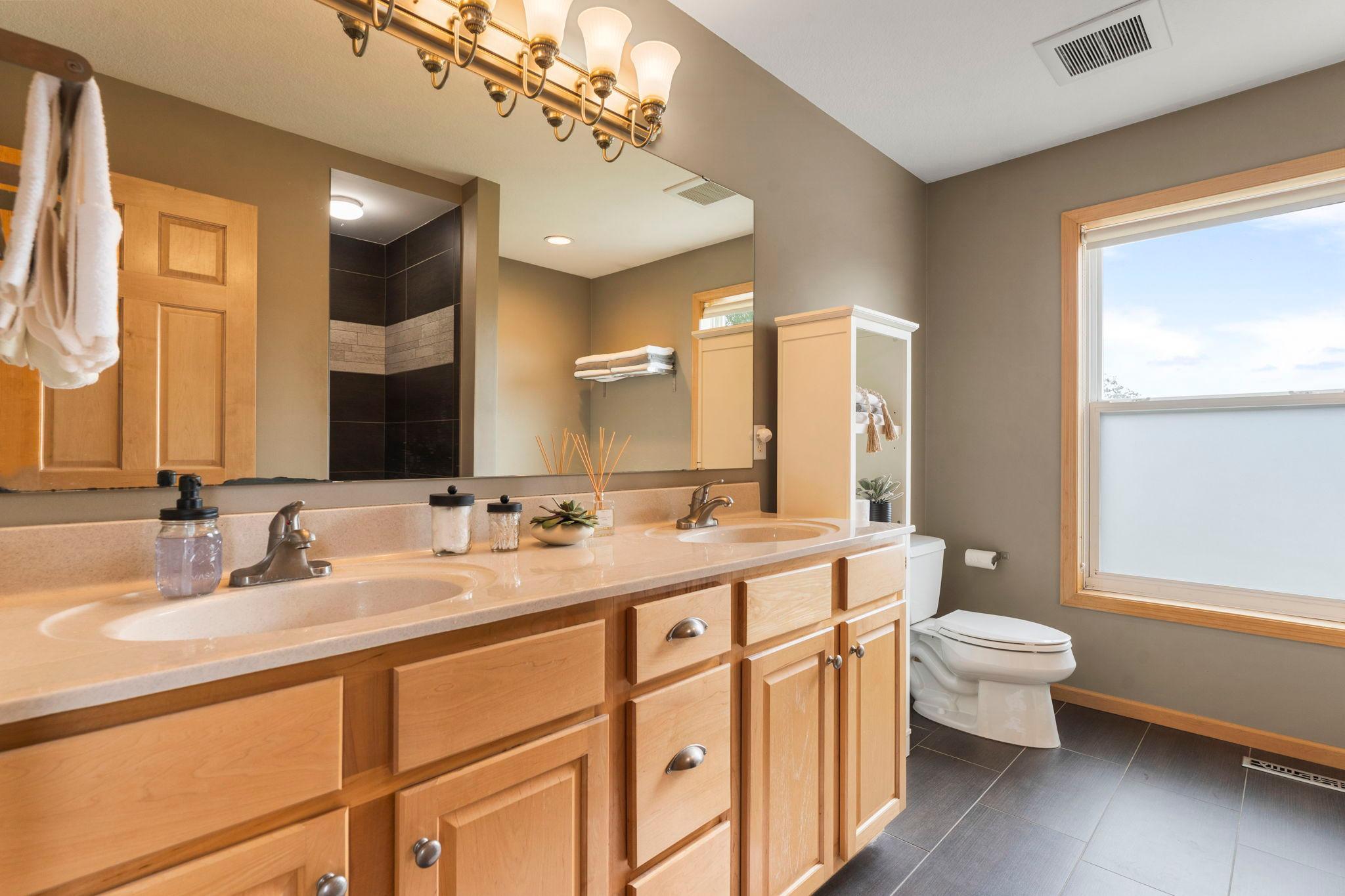 The private ensuite bathroom offers dual vanities, a separate shower, and a soaking tub perfect for unwinding.