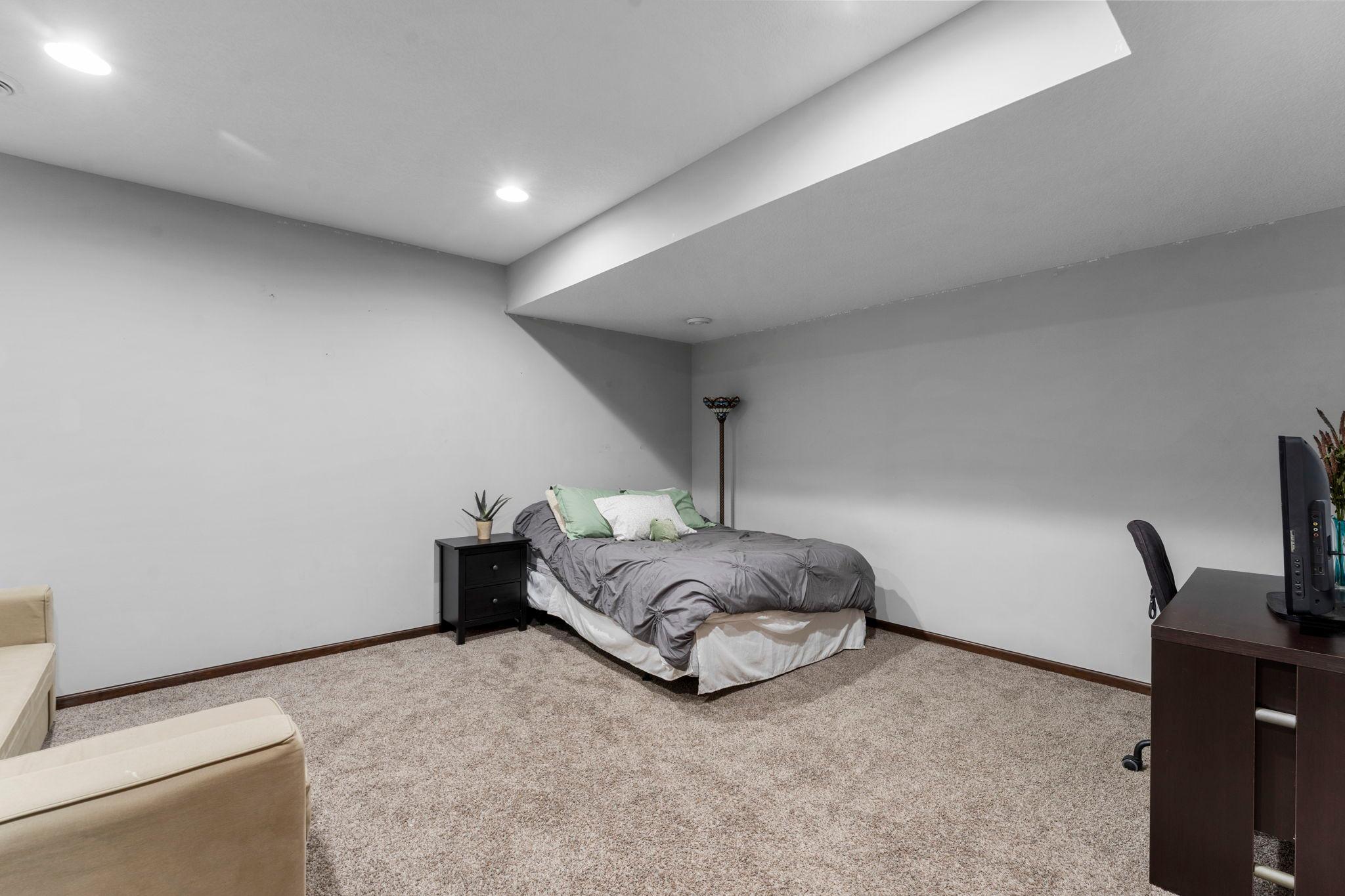 An additional bedroom features carpeting, a large walk-in closet, and an egress window.