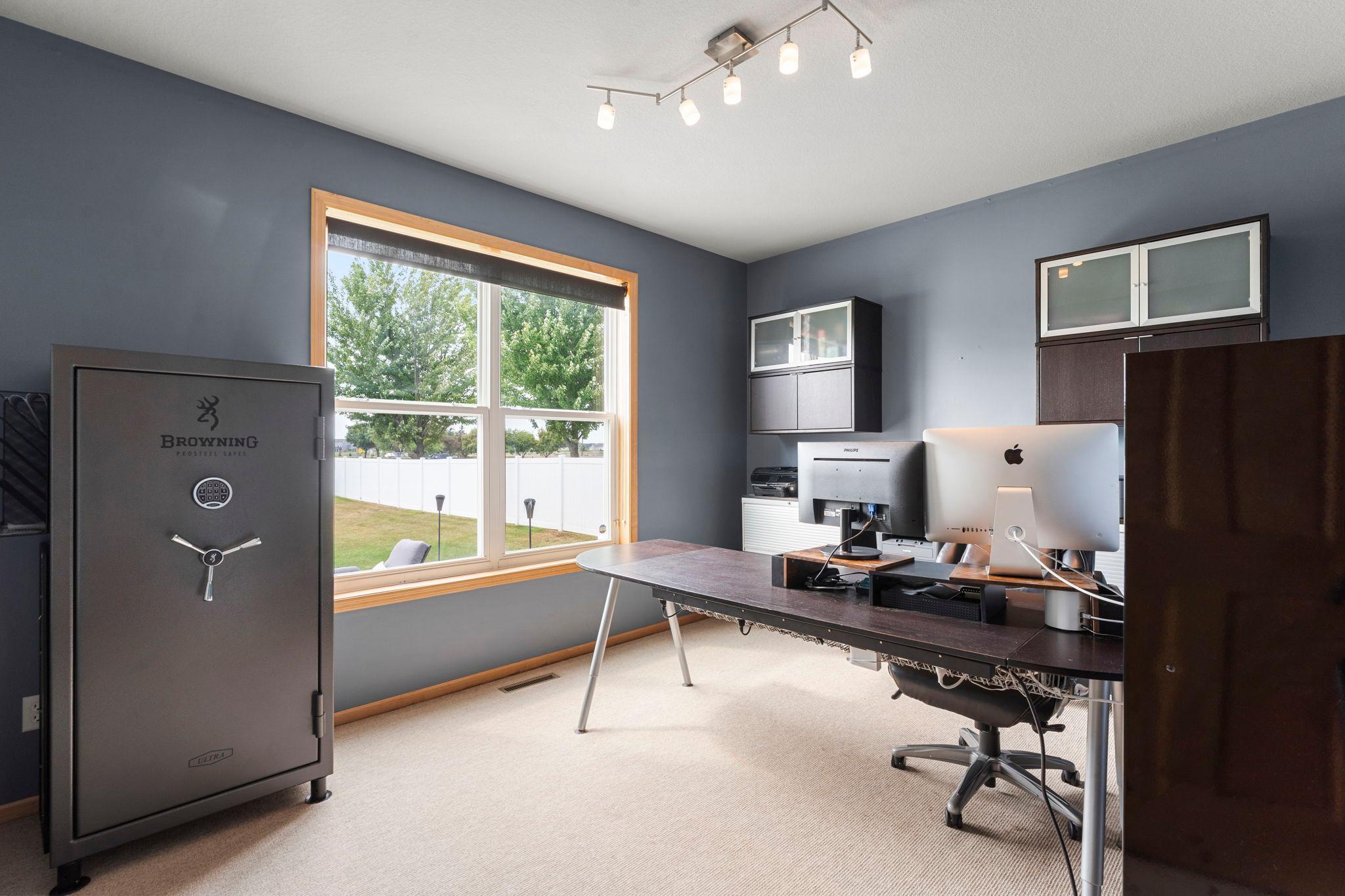 A main-level bedroom or office with built-in storage and carpeting provides flexibility for a variety of needs.