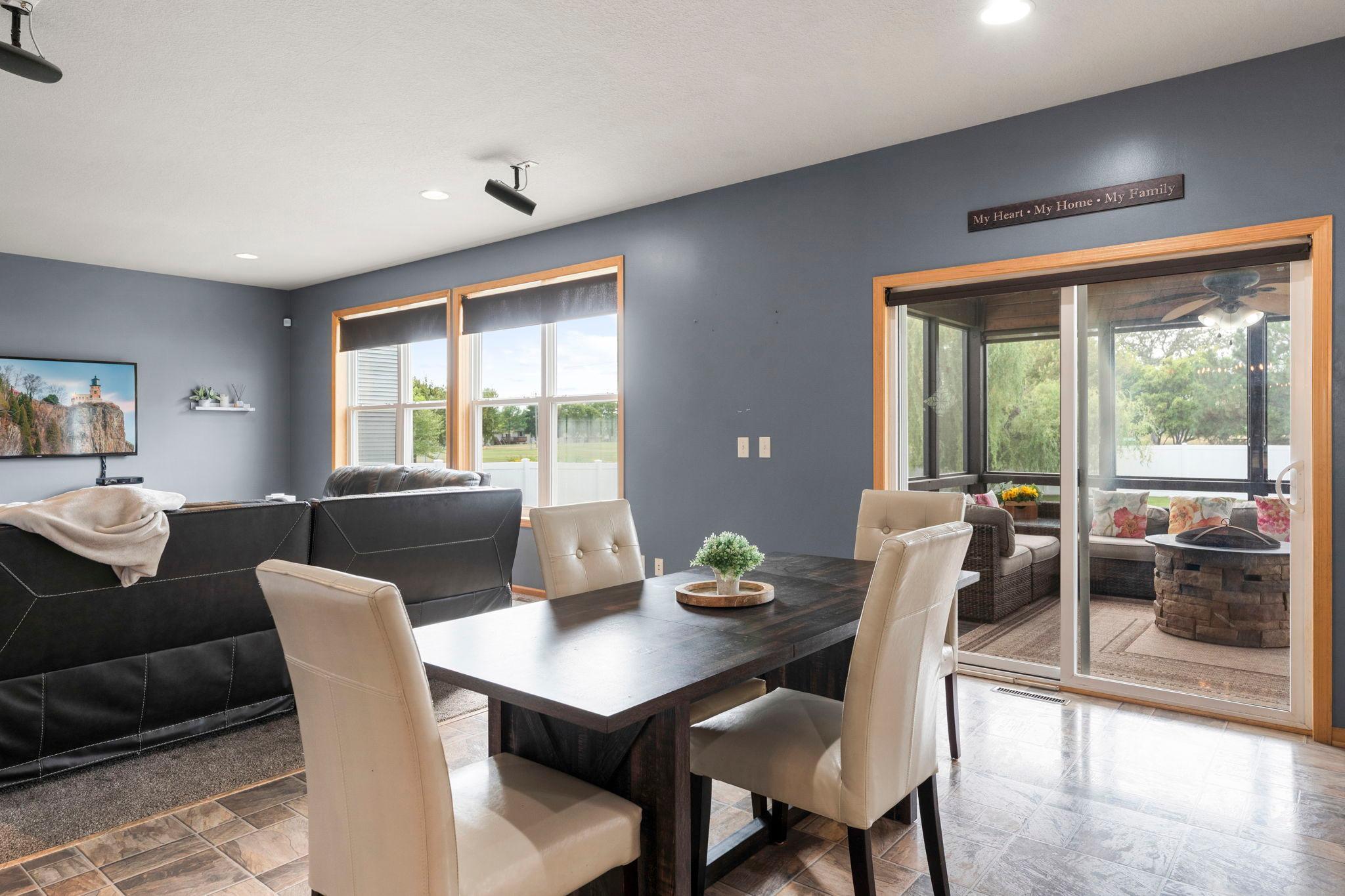 The kitchen flows seamlessly into the informal dining area, complete with a classic chandelier and access to the screened-in three-season porch.