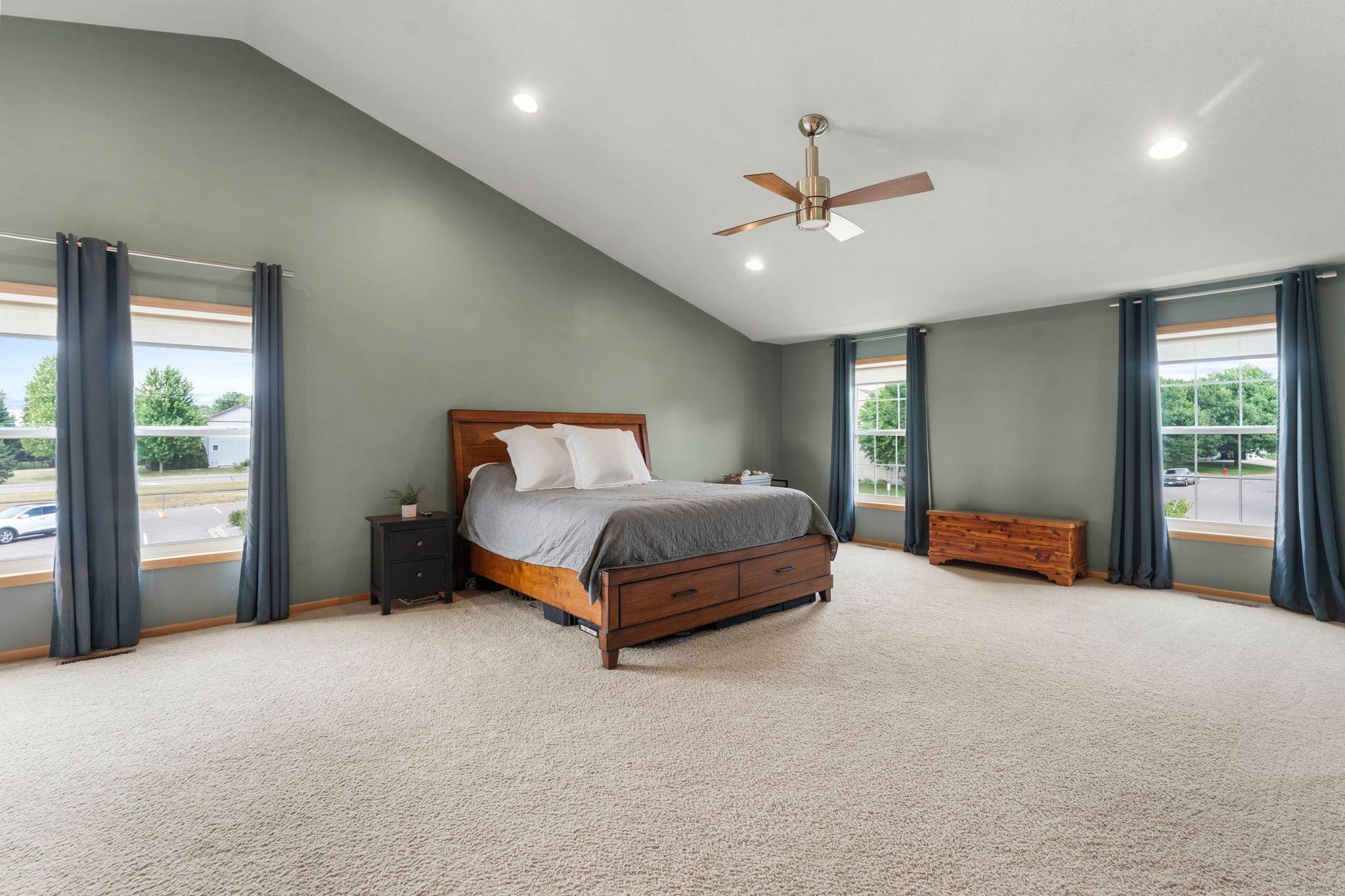 Upstairs, you’ll find four bedrooms, including an impressive primary suite featuring vaulted ceilings, a walk-in closet, carpeting, and large windows that fill the space with natural light.