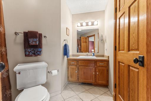 This space boasts a wood vanity, tile flooring and neutral finishes.