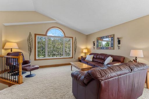 Vaulted ceilings, a large window, and neutral paint create a bright and airy upper level.