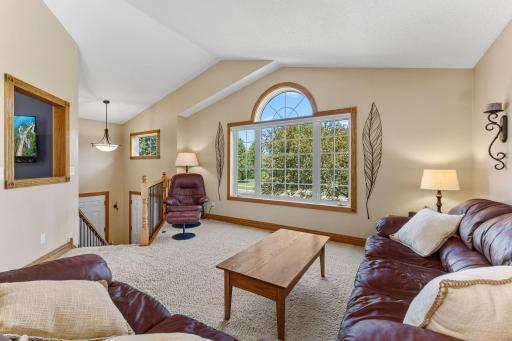 The upper level is bright and features a vaulted ceiling and large windows that fill the space with natural light.