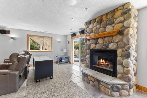 Stone fireplace creates a warm focal point in the lower level living space.