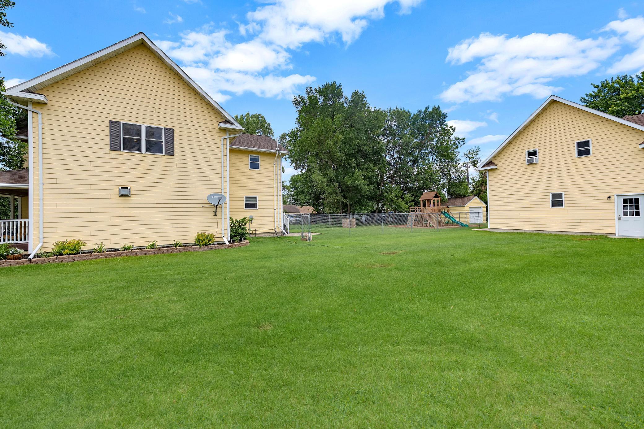 Large yard, partially fenced, with huge garage