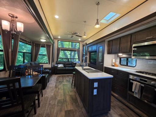Center island with dining area, living room with fireplace and large TV, beautiful appliances - all ready for your weekend escape or all-summer home.