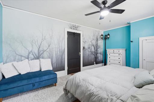 Primary bedroom at the top of the stairs with a classic mural on the wall.