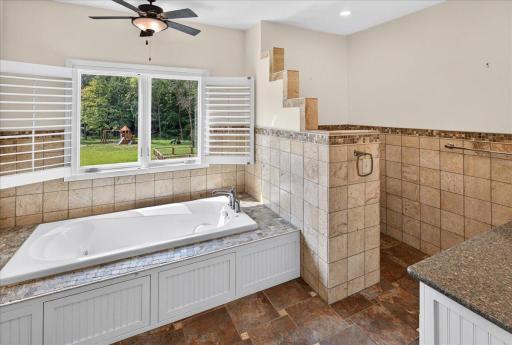 Intricate tile work on floors, walls and surrounding the tub.
